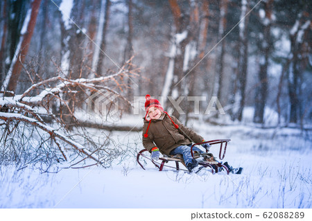 Panorama of the snow covered forest with a child sledding Panorama of the snow covered forest with a child sledding 62088289