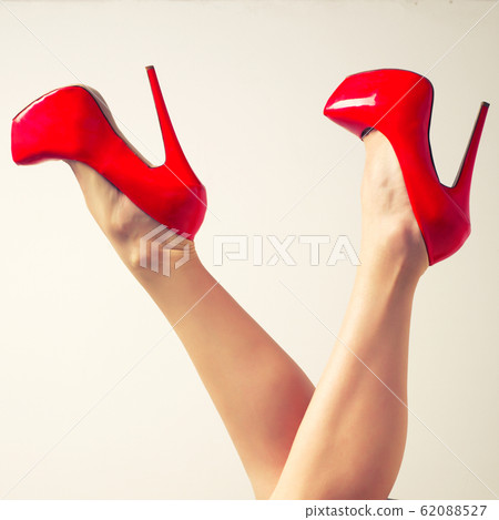 Perfect female legs wearing red high heels Perfect female legs wearing red high heels 62088527