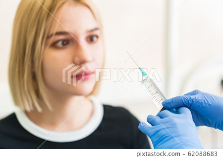 Girl shows she is afraid of injection Girl shows she is afraid of injection 62088683