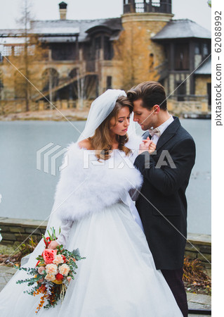 Couple of stylish newlyweds posing on the territory of country hotel 62088992