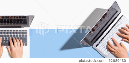 Two people working together with laptops 62089480