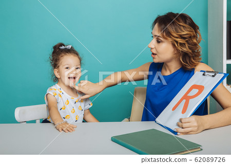 Speech therapy concept. Kid with therapist learning letters together. 62089726