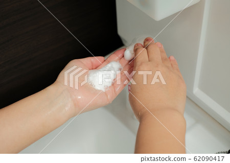 Hand of woman applying medicated soap to wash hands immediately after returning home to prevent infectious disease Hand of woman applying medicated soap to wash hands immediately after returning home to prevent infectious disease 62090417