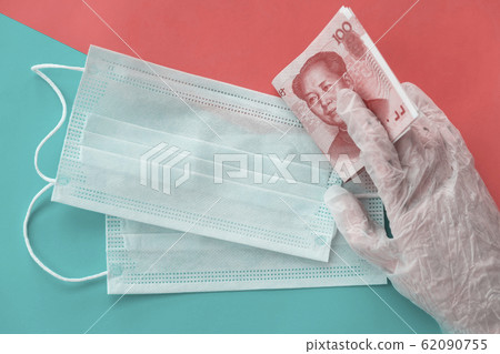 Cash chinese money and medical disposable personal masks in hand in protective glove. Healthcare and coronavirus concept, quarantine and deficiency of personal protection 62090755