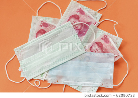 Disposable protective masks and cash chinese money on orange background. Concept of medicines deficiency, personal protection, outbreak of dangerous coronovirus Disposable protective masks and cash chinese money on orange background. Concept of medicines deficiency, personal protection, outbreak of dangerous coronovirus 62090758