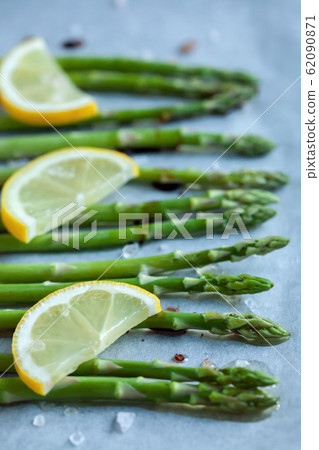 asparagus prepared for baking with lemon 62090871