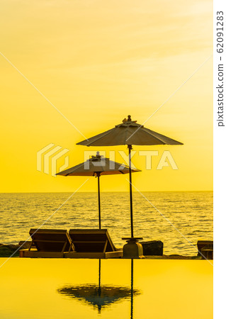 Umbrella and chair around swimming pool in resort hotel for leisure travel and vacation 62091283