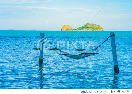 Empty hammock around beautiful beach sea ocean for relax in holiday vacation Empty hammock around beautiful beach sea ocean for relax in holiday vacation 62091659