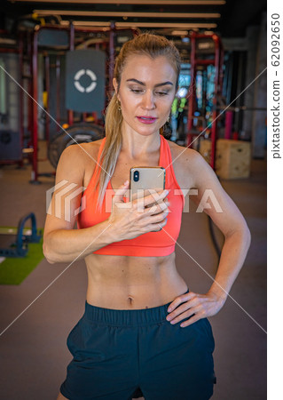 Young woman taking selfie photo by mirror after exercising at the gym 62092650