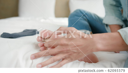 applying cream for athletes foot 62093379