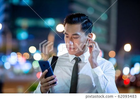 asian man wear wireless earbuds 62093483