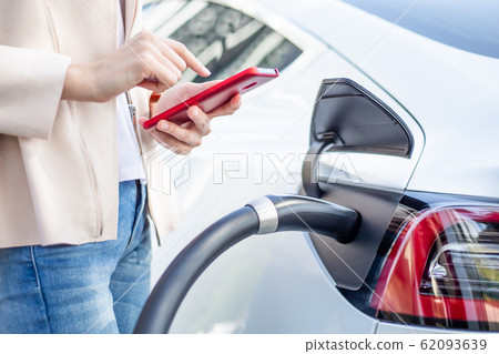Woman charging electric car Woman charging electric car 62093639