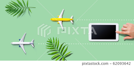 Person using a tablet computer with small airplanes Person using a tablet computer with small airplanes 62093642