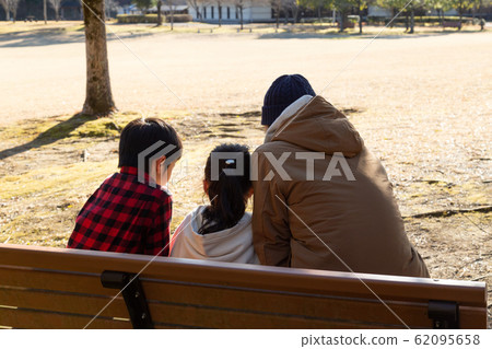 父母和孩子坐在長凳上 62095658