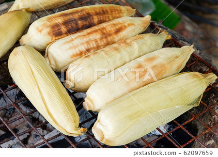 Grilled corn cobs on grill in the stove background Grilled corn cobs on grill in the stove background 62097659