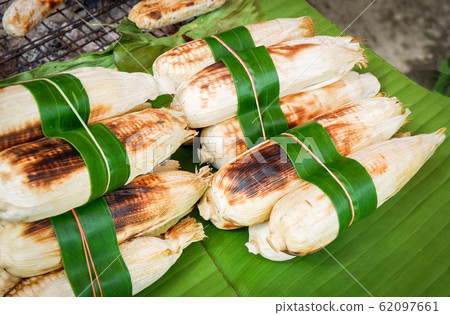 Grilled corn cobs on banana leaf background Grilled corn cobs on banana leaf background 62097661