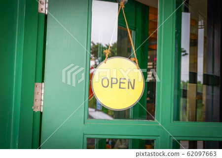 Open sign board yellow hanging on wooden door cafe Open sign board yellow hanging on wooden door cafe 62097663