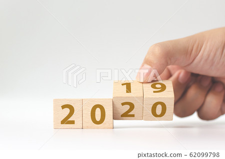 New year 2019 change to 2020 concept. Hand flip over wood cube block New year 2019 change to 2020 concept. Hand flip over wood cube block 62099798