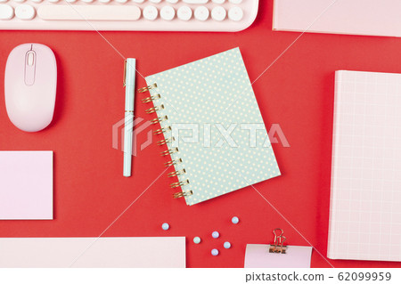 flat lay stationery on work desk in red pastel background 62099959