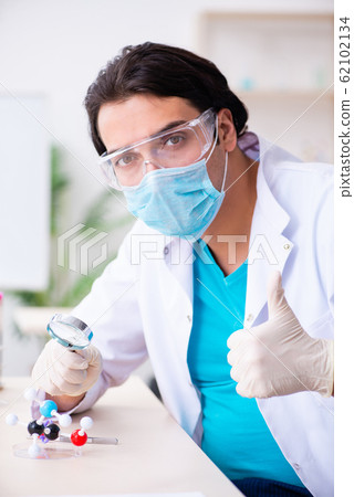 Young male chemist working in the lab 62102134