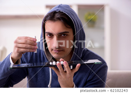 Young man having problems with narcotics at home 62102243