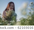 Asian beautiful woman surrounded by flowers 62103016