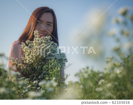 Asian beautiful woman surrounded by flowers Asian beautiful woman surrounded by flowers 62103016