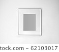 Blank white picture frame on white wall. 62103017