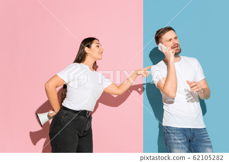 Young emotional man and woman on pink and blue background 62105282