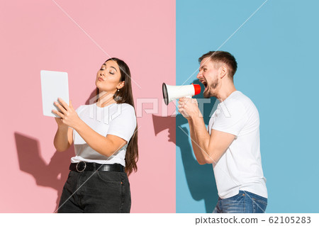 Young emotional man and woman on pink and blue background Young emotional man and woman on pink and blue background 62105283