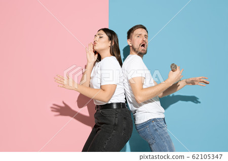 Young emotional man and woman on pink and blue background Young emotional man and woman on pink and blue background 62105347