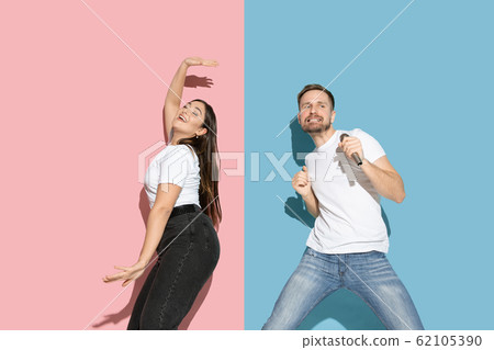 Young emotional man and woman on pink and blue background 62105390
