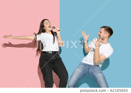 Young emotional man and woman on pink and blue background 62105683