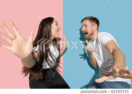 Young emotional man and woman on pink and blue background 62105731