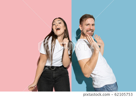 Young emotional man and woman on pink and blue background 62105753