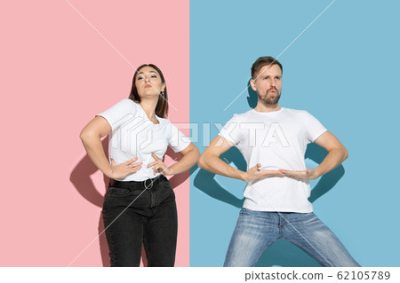 Young emotional man and woman on pink and blue background Young emotional man and woman on pink and blue background 62105789