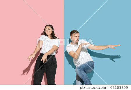 Young emotional man and woman on pink and blue background Young emotional man and woman on pink and blue background 62105809