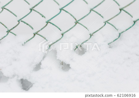Snow bank and metalic fence, winter background Snow bank and metalic fence, winter background 62106916