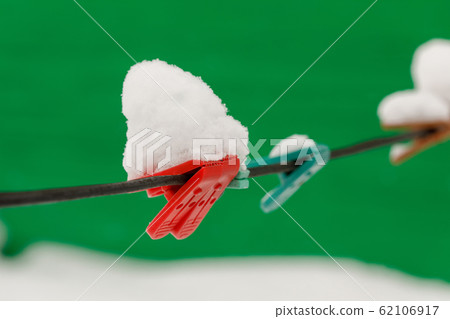Clothespins on clothesline covered with snow Clothespins on clothesline covered with snow 62106917