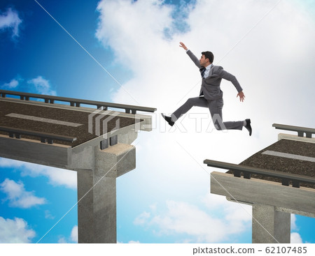Young businessman jumping over the bridge 62107485