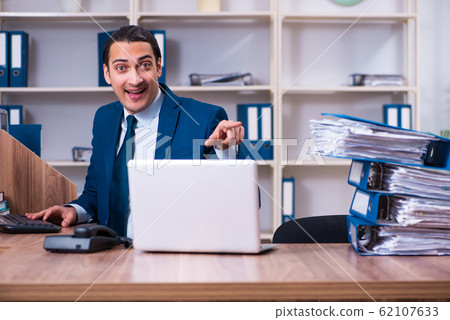 Young handsome businessman working in the office Young handsome businessman working in the office 62107633