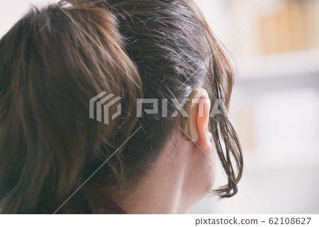 Deaf woman wearing hearing aid Deaf woman wearing hearing aid 62108627