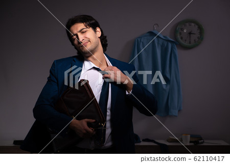Young employee working at home after night shift 62110417