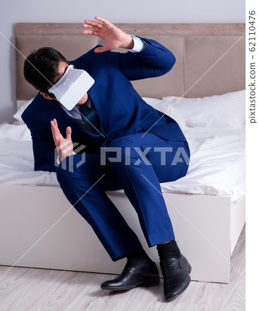 Businessman wearing a virtual reality headset in the bedroom 62110476