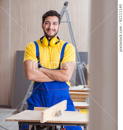 Young repairman carpenter working cutting wood on circular saw 62111140