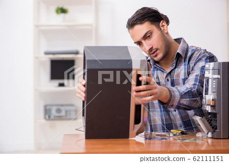 Young engineer repairing musical hi-fi system Young engineer repairing musical hi-fi system 62111151