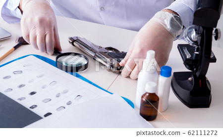 Criminologist police chemist looking at crime evidence Criminologist police chemist looking at crime evidence 62111272