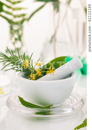 White mortar and pestle with herbs. White mortar and pestle with herbs. 62112189