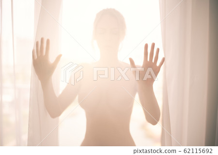 Defocus. High key light silhouette of a beautiful 62115692