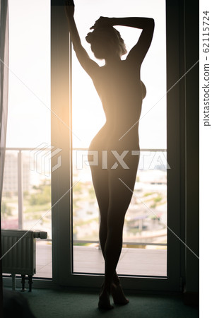 Dark silhouette of a beautiful slender nude woman Dark silhouette of a beautiful slender nude woman 62115724